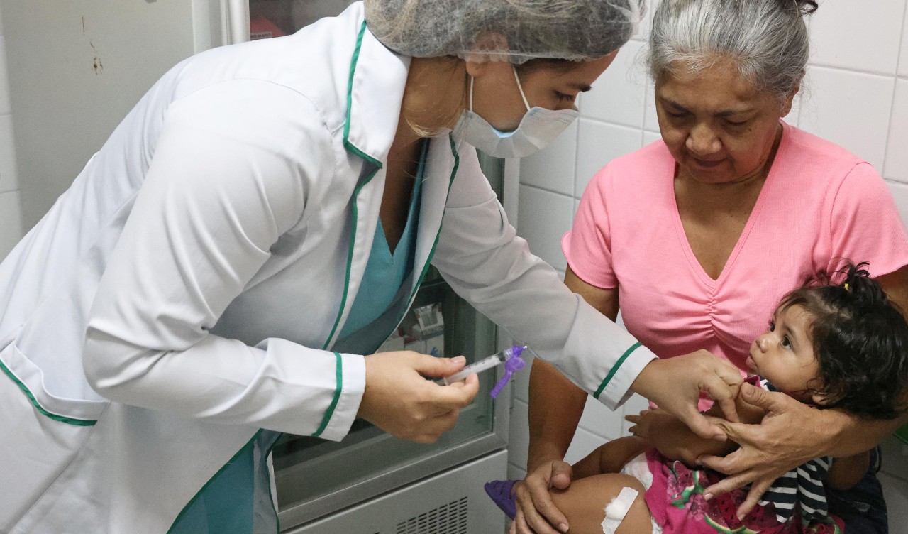 enfermeira aplicando vacina numa criança